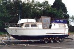 A home made boat full of character being towed from Cobbs Quay Marina to London